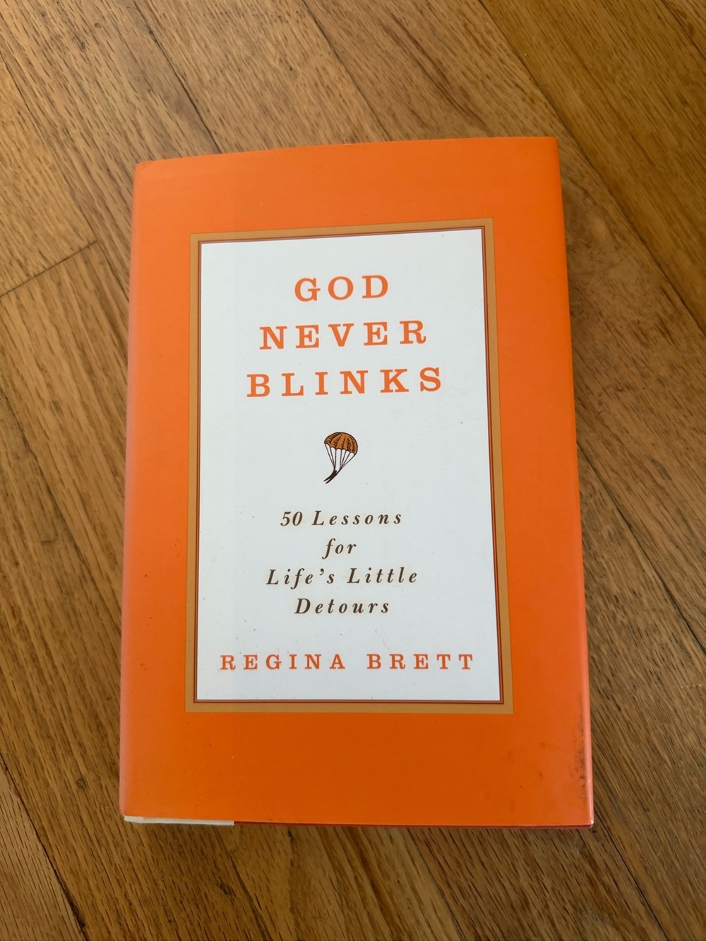 God Never Blinks by Regina Brett - Orange Cover book